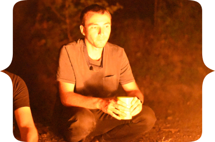 Myself squating in front of a firecamp. Here I'm sorounded by longtime friends off-camera. I love them. They are part of what make me who I am today.