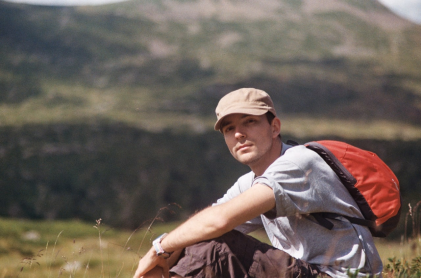 Myself outside, wearing a cap, during a hike in the mountains
